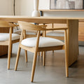 Chaise de cuisine en bois merisier avec assise rembourrée cuir végane beige style scandinave.
