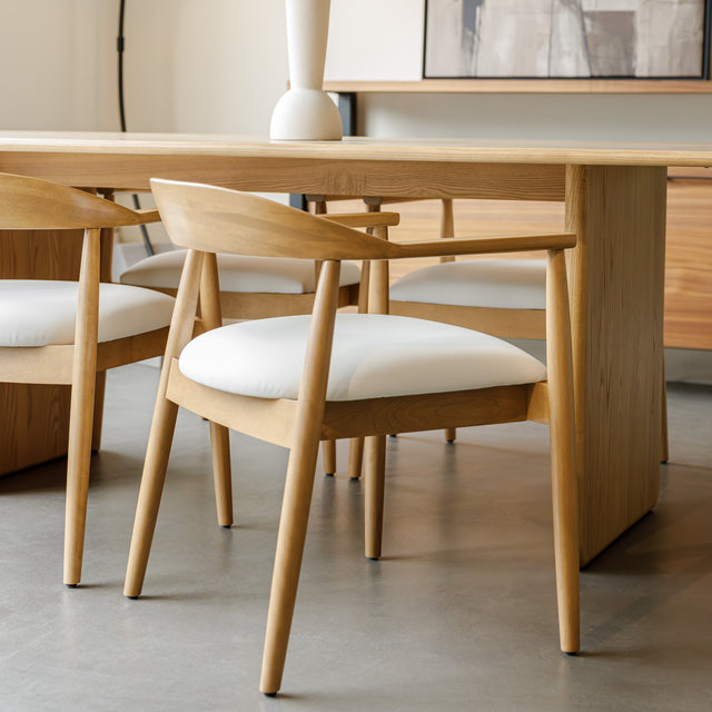 Chaise de cuisine en bois merisier avec assise rembourrée cuir végane beige style scandinave.