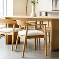 Chaise de cuisine en bois merisier avec assise rembourrée cuir végane beige style scandinave.