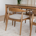 Chaise de cuisine en bois merisier avec assise rembourrée beige style scandinave.