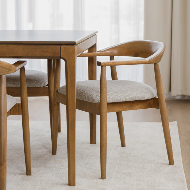 Chaise de cuisine en bois merisier avec assise rembourrée beige style scandinave.
