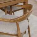 Chaise de cuisine en bois merisier avec assise rembourrée beige style scandinave.