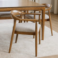 Chaise de cuisine en bois merisier avec assise rembourrée beige style scandinave.
