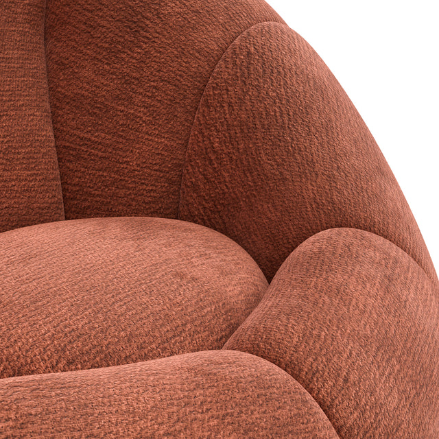 Fauteuil design arrondi terracotta en tissu, sur fond neutre.