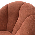 Fauteuil design arrondi terracotta en tissu, sur fond neutre.