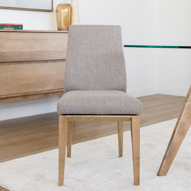 Chaise de cuisine en tissu beige avec pieds en bois naturel dans un intérieur moderne.