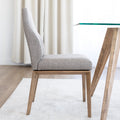 Chaise de cuisine en tissu beige avec pieds en bois naturel dans un intérieur moderne.