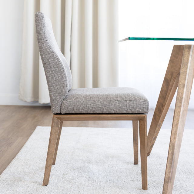Chaise de cuisine en tissu beige avec pieds en bois naturel dans un intérieur moderne.