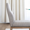 Chaise de cuisine en tissu beige avec pieds en bois naturel dans un intérieur moderne.
