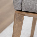 Chaise de cuisine en tissu beige avec pieds en bois naturel dans un intérieur moderne.