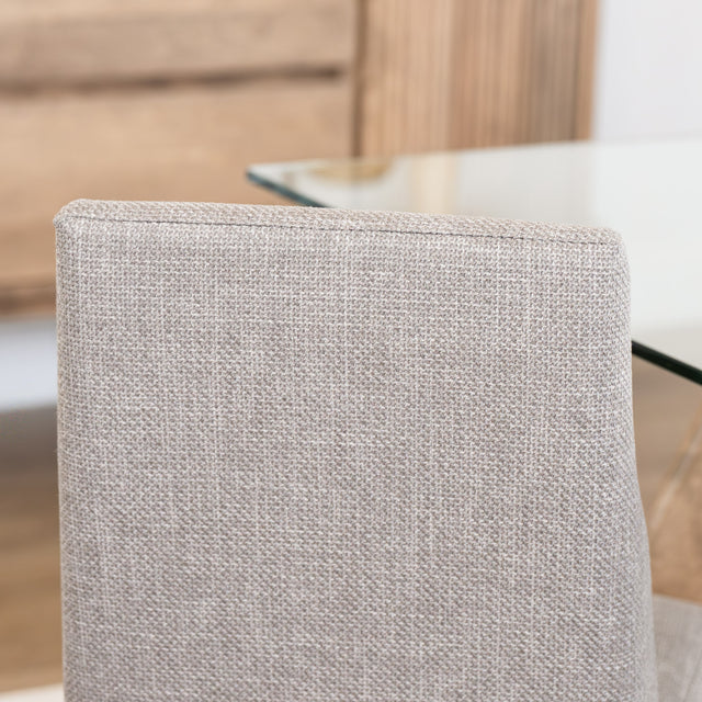 Chaise de cuisine en tissu beige avec pieds en bois naturel dans un intérieur moderne.