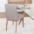 Chaise de cuisine en tissu beige avec pieds en bois naturel dans un intérieur moderne.