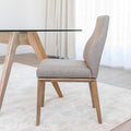 Chaise de cuisine en tissu beige avec pieds en bois naturel dans un intérieur moderne.