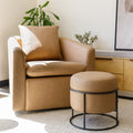 Ottoman rond en cuir végane mocha avec structure noire au style moderne et élégant.