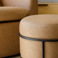 Ottoman rond en cuir végane mocha avec structure noire au style moderne et élégant.