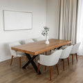 table a manger en bois massif avec pieds metalliques noirs et chaises blanches modernes dans salle lumineuse.
