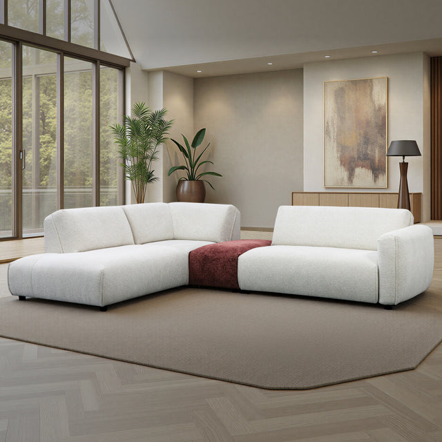 sofa modulaire en tissu crème marbré et tissu bordeau, au design contemporain, installé dans un salon spacieux et lumineux. 
