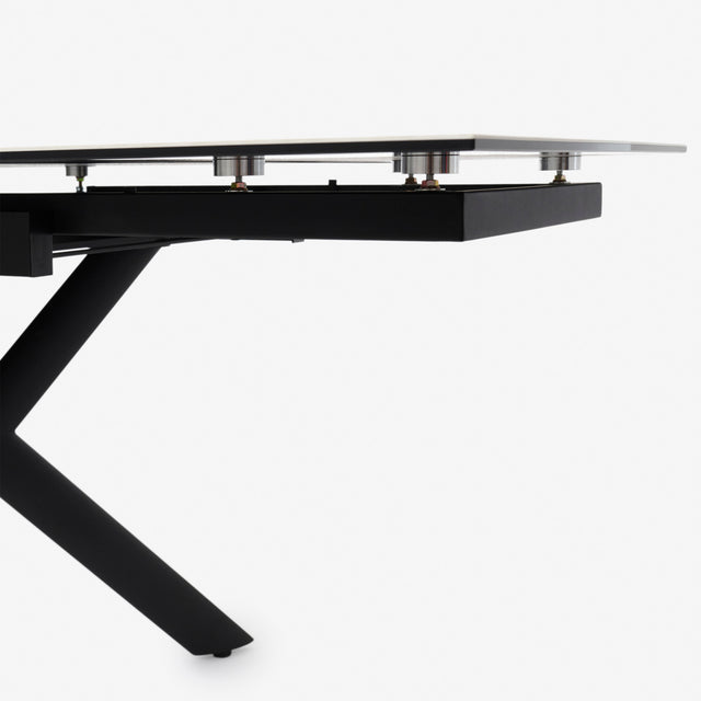 table extensible avec plateau effet marbre clair et pieds en metal noir.