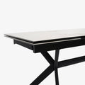 table extensible avec plateau effet marbre clair et pieds en metal noir.