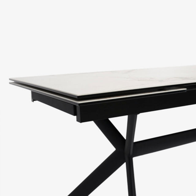 table extensible avec plateau effet marbre clair et pieds en metal noir.