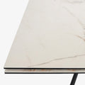 table extensible avec plateau effet marbre clair et pieds en metal noir.
