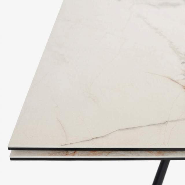 table extensible avec plateau effet marbre clair et pieds en metal noir.