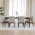 Table de salle à manger rectangulaire en bois foncé et chaises rembourrées beige au design contemporain.