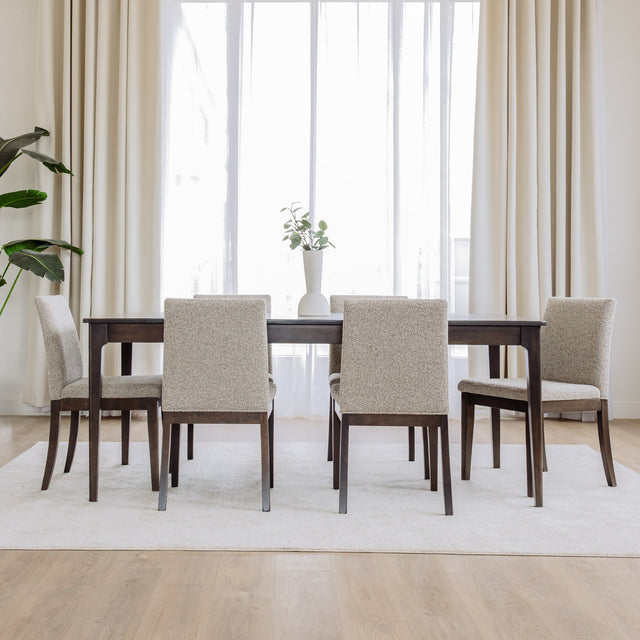 Table de salle à manger rectangulaire en bois foncé et chaises rembourrées beige au design contemporain.