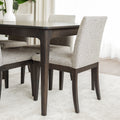 Table de salle à manger rectangulaire en bois foncé et chaises rembourrées beige au design contemporain.