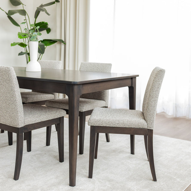 Table de salle à manger rectangulaire en bois foncé et chaises rembourrées beige au design contemporain.