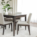 Table de salle à manger rectangulaire en bois foncé et chaises rembourrées beige au design contemporain.