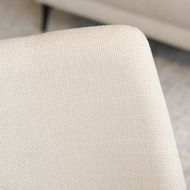 Chaise de salle à manger en tissu beige avec piètement noirs, placée près d’une table en bois dans un intérieur moderne.