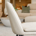 Chaise de salle à manger en tissu beige avec piètement noirs.
