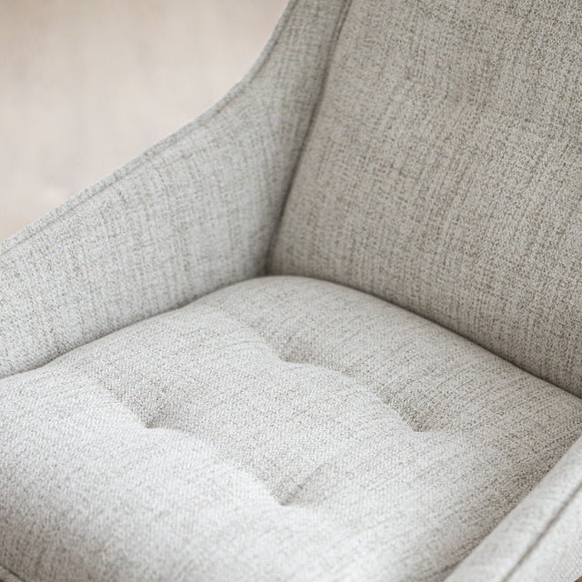 Chaise de salle à manger en tissu truffle sauvage avec piétement en bois noyer, placée près d’une table en bois moderne.