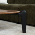 Table basse triangulaire en bois avec pieds noirs, au design contemporain dans un salon lumineux.