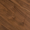 Table basse triangulaire en bois avec pieds noirs, au design contemporain dans un salon lumineux.