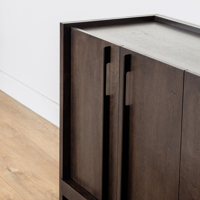 Buffet de rangement en bois foncé à quatre portes, design contemporain avec poignées intégrées et lignes épurées.