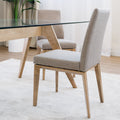 Chaise de cuisine en tissu beige avec structure en bois naturel près d’une table contemporaine.
