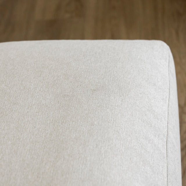 gros plan sur tissu beige clair du pouf avec legere marque sur la surface.

