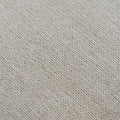 gros plan sur texture du tissu beige clair du pouf en maille fine.
