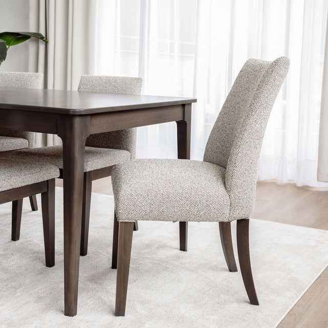 Chaise de salle à manger rembourrée en tissu beige avec pattes en bois foncé, style contemporain et confortable.