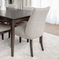 Chaise de salle à manger rembourrée en tissu beige avec pattes en bois foncé, style contemporain et confortable.