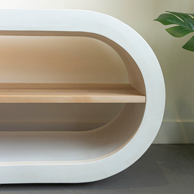 Meuble TV moderne en bois clair avec structure en béton blanc, rangements fermés et etagere ouverte, ideal pour salon contemporain.