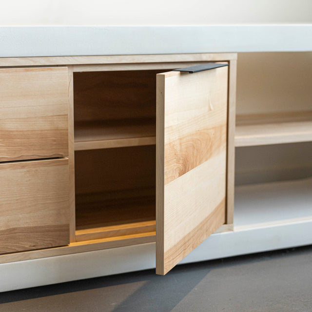 Meuble TV moderne en bois clair avec structure en béton blanc, rangements fermés et etagere ouverte, ideal pour salon contemporain.