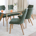 Chaise rembourrée en tissu vert avec dossier incurvé et pieds en bois, autour d’une table à manger au design moderne.
