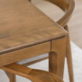 Table de cuisine en bois avec chaises rembourrées dans un intérieur minimaliste lumineux.