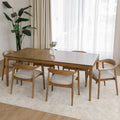 Table de cuisine en bois avec chaises rembourrées dans un intérieur minimaliste lumineux.