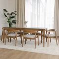 Table de cuisine en bois avec chaises rembourrées dans un intérieur minimaliste lumineux.