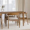 Table de cuisine en bois avec chaises rembourrées dans un intérieur minimaliste lumineux.
