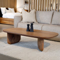 Table basse ovale en bois noyer dans un salon moderne avec un canapé beige.